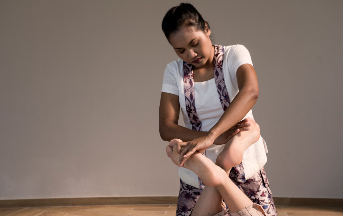 Massage Therapist administering a Thai massage 